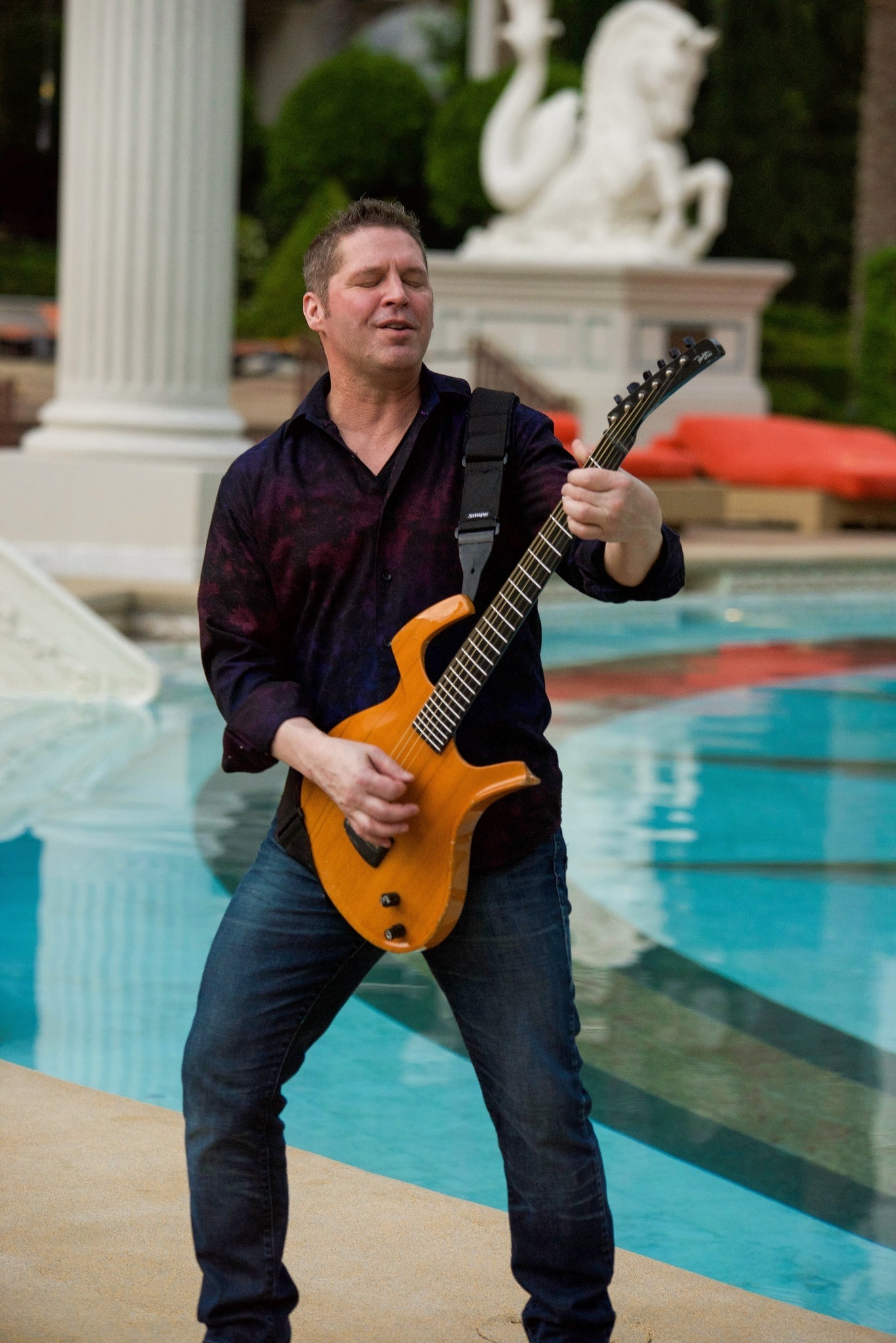 Chad playing guitar by pool